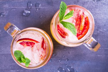Kokteyl ile portakal, nane ile süslenmiş.