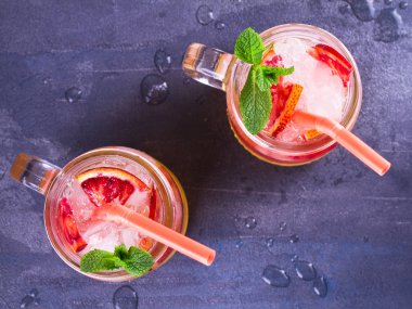 Kokteyl ile portakal, nane ile süslenmiş.