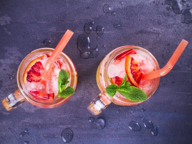 Kokteyl ile portakal, nane ile süslenmiş.