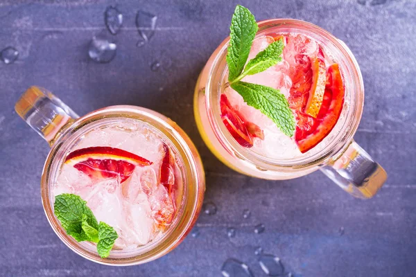 Kokteyl ile portakal, nane ile süslenmiş.