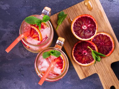 Kokteyl ile portakal, nane ile süslenmiş.