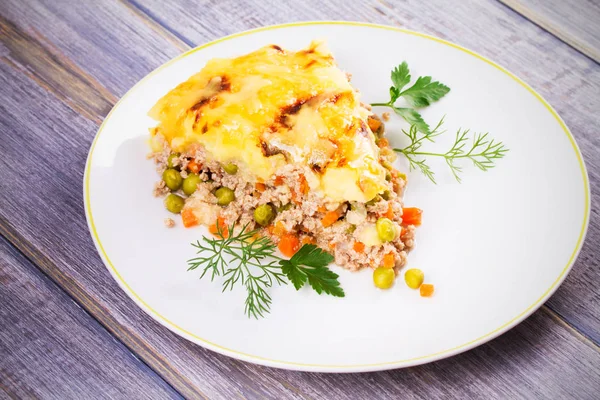 Traditional shepherd pie. Meat, potato, cheese, carrot, onion and green peas casserole — Stock Photo, Image