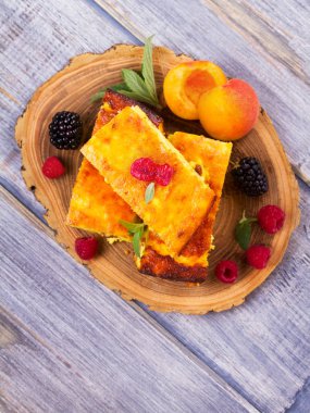 Cheesecake, çilek ve şeftali ile süslenmiş