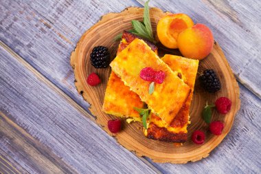 Cheesecake, çilek ve şeftali ile süslenmiş