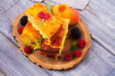 Cheesecake, çilek ve şeftali ile süslenmiş