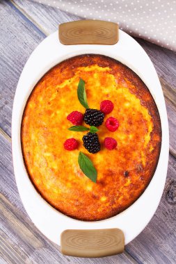 Cheesecake, çilek, nane ve şeftali ile süslenmiş. Tatlı çiftçi peynir (süzme peynir) güveç