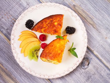 Cheesecake, çilek, nane ve şeftali ile süslenmiş. Tatlı çiftçi peynir (süzme peynir) güveç