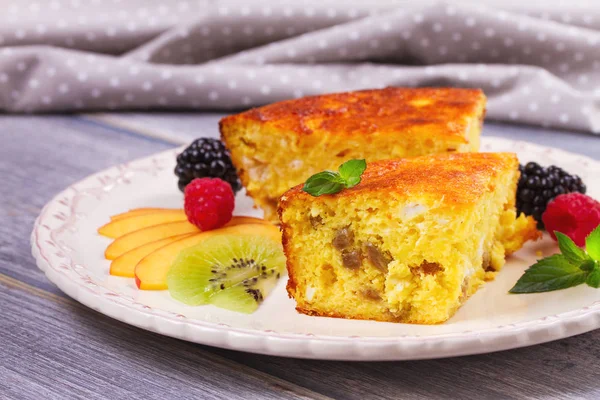 Cheesecake, çilek, nane ve şeftali ile süslenmiş. Tatlı çiftçi peynir (süzme peynir) güveç