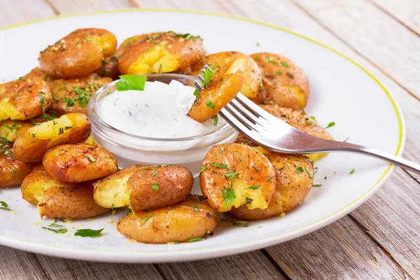 Krossad potatis med persilja, torkad rosmarin, citronskal och yoghurt sås — Stockfoto