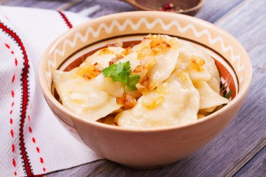 Varenyky, vareniki, pierogi, pyrohy veya köfte, patates ile dolu ve tuzlu karamelize soğan ile servis