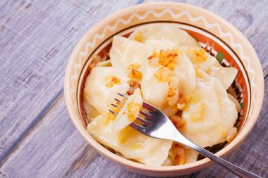 Varenyky, vareniki, pierogi, pyrohy veya köfte, patates ile dolu ve tuzlu karamelize soğan ile servis