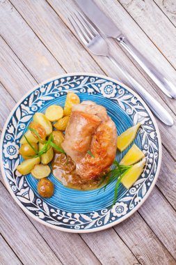 Tavşan patates, limon ve tarhun mavi plaka üzerinde