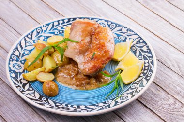 Tavşan patates, limon ve tarhun mavi plaka üzerinde
