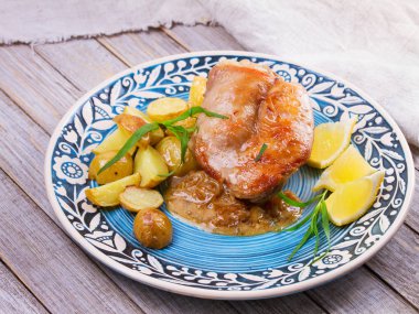 Tavşan patates, limon ve tarhun mavi plaka üzerinde