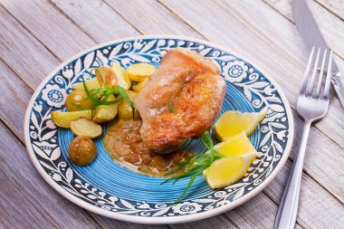 Tavşan patates, limon ve tarhun mavi plaka üzerinde