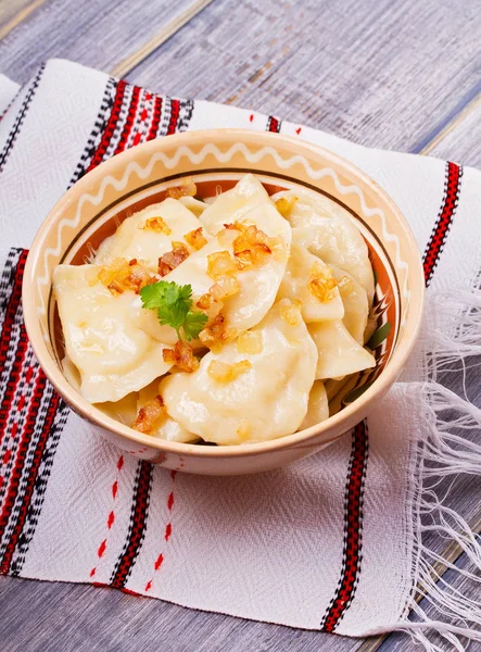 Varenyky, vareniki, pierogi, pyrohy or dumplings, filled with potato and served with salty caramelized onion — Stock Photo, Image