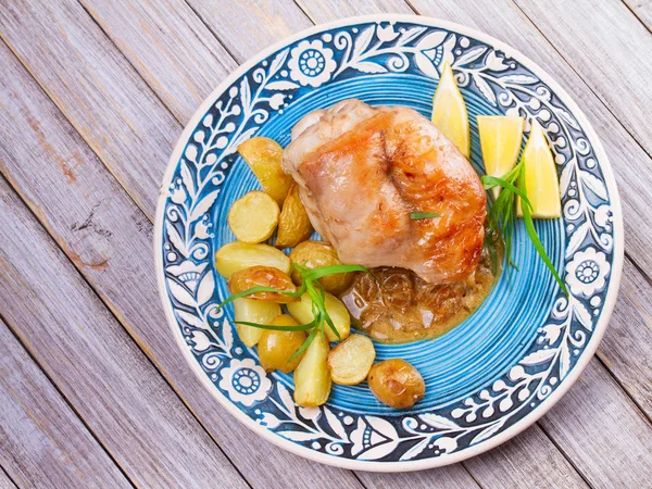 Кролик с картошкой, лимоном и эстрагоном на голубой тарелке — стоковое фото