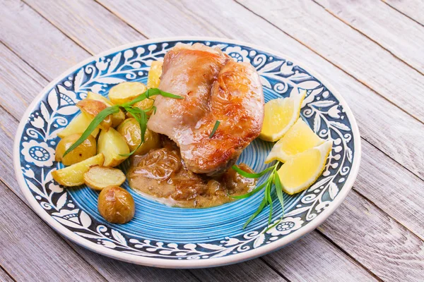 Кролик с картошкой, лимоном и эстрагоном на голубой тарелке — стоковое фото