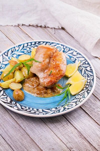 Conejo con patatas, limón y estragón en plato azul — Foto de Stock