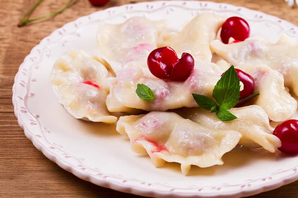 Varenyky, vareniki, pierogi, pyrohy ou boulettes, remplis de cerises, peuvent être servis avec du beurre et du miel. Varenyky avec remplissage de baies — Photo