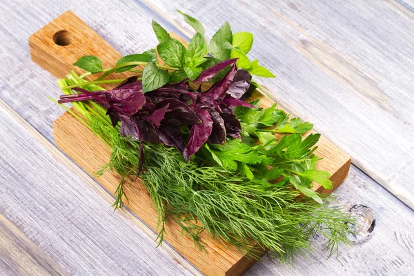 Kruiden op houten snijplank: Dille, peterselie, munt en basilicum. Culinaire kruiden voor het koken en eten bijgerechten — Stockfoto