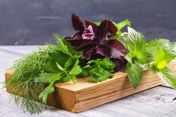 Herbes sur planche à découper : persil, menthe, basilic et aneth. Herbes culinaires pour la cuisson et la garniture des aliments — Photo