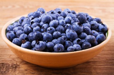 Yaban mersini kil kase. Taze çilek rustik arka plan üzerinde aldı