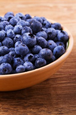 Yaban mersini kil kase. Taze çilek rustik arka plan üzerinde aldı