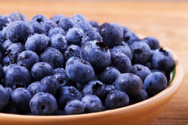 Yaban mersini kil kase. Taze çilek rustik arka plan üzerinde aldı