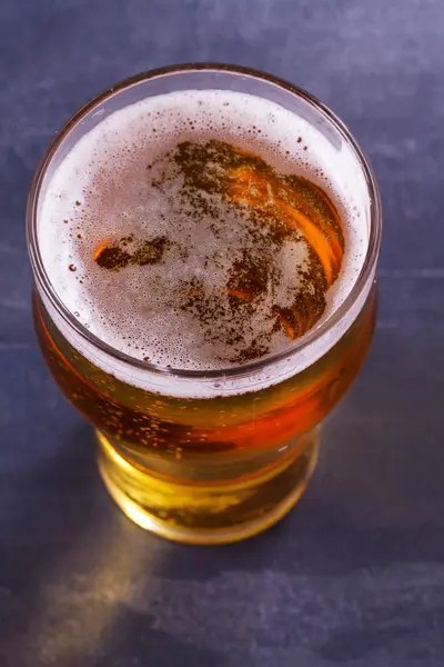 Glass of beer on gray background. Ale