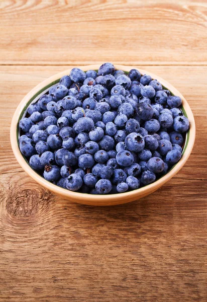 Yaban mersini kil kase. Taze çilek rustik arka plan üzerinde aldı