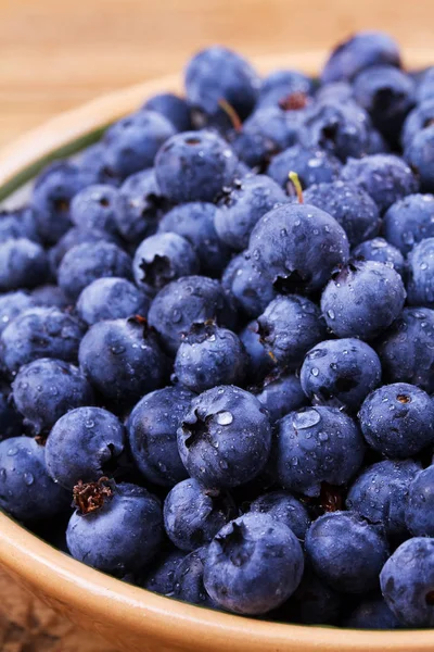 Yaban mersini kil kase. Taze çilek rustik arka plan üzerinde aldı