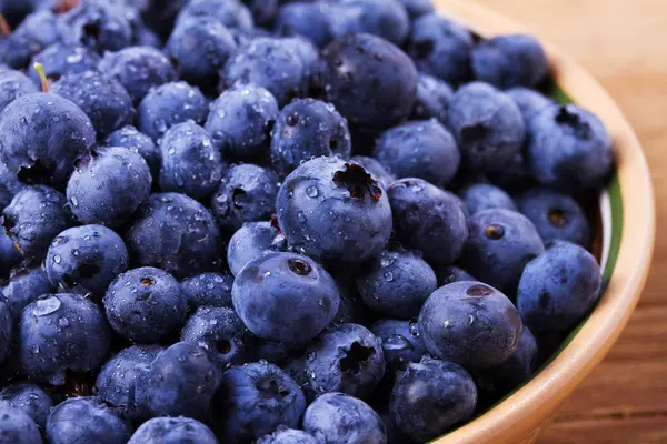 Yaban mersini kil kase. Taze çilek rustik arka plan üzerinde aldı