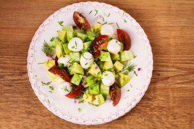 Domates, salatalık ve mozzarella ile Avokado salatası. Peynir ve sebze salatası