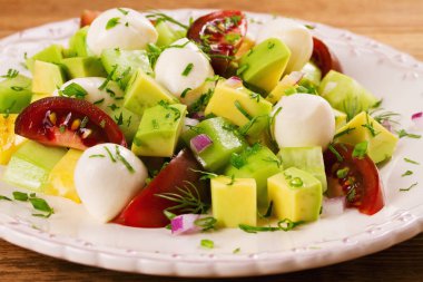 Domates, salatalık ve mozzarella ile Avokado salatası. Peynir ve sebze salatası