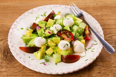 Domates, salatalık ve mozzarella ile Avokado salatası. Peynir ve sebze salatası