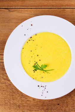 Ahşap arka plan üzerinde bir kapta krem Mısır çorbası