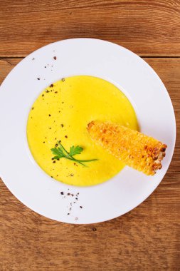 Ahşap arka plan üzerinde bir kapta krem Mısır çorbası