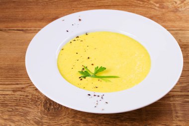 Ahşap arka plan üzerinde bir kapta krem Mısır çorbası