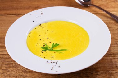 Ahşap arka plan üzerinde bir kapta krem Mısır çorbası