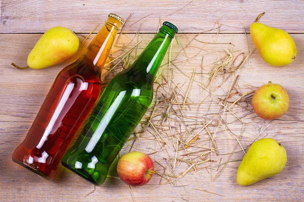 Botellas de manzana y sidra de pera con frutas. Concepto de alimentos y bebidas — Foto de Stock