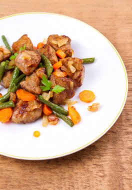 Sebze ile karaciğer sığır eti: havuç, soğan ve yeşil fasulye beyaz plaka üzerinde