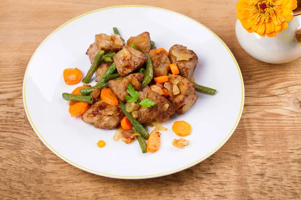 Sebze ile karaciğer sığır eti: havuç, soğan ve yeşil fasulye beyaz plaka üzerinde