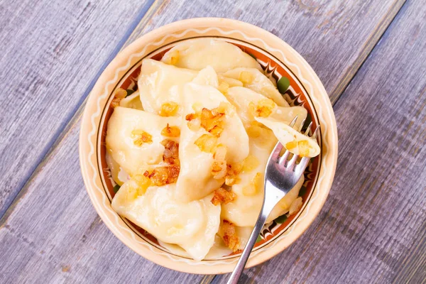 Knödel, gefüllt mit Kartoffeln und serviert mit gebratenen Zwiebeln. varenyky, vareniki, pierogi, pyrohy - beliebtes Gericht in Osteuropa — Stockfoto