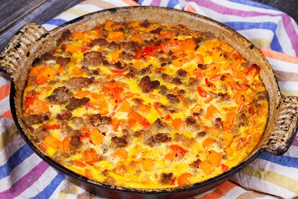 Фриттата - блюдо из жареных взбитых яиц, тыквы (или ореховой тыквы), колбасы и красного перца — стоковое фото