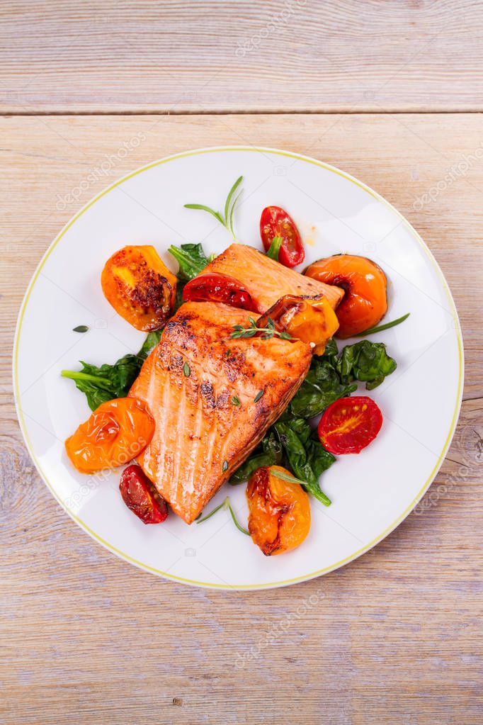 Salmon fillet with spinach, tomatoes and herbs