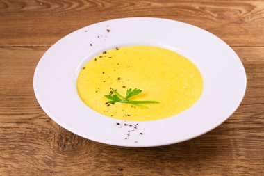 Kremalı Mısır çorbası biber, yeşil soğan ve maydanoz ile süslenmiş beyaz kase