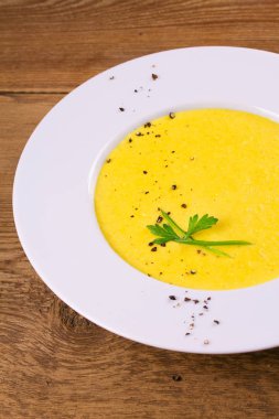 Kremalı Mısır çorbası biber, yeşil soğan ve maydanoz ile süslenmiş beyaz kase