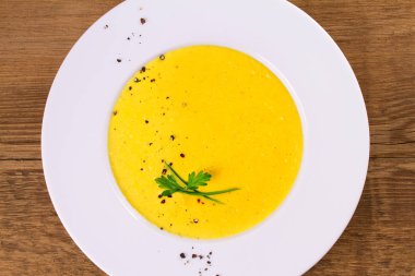 Kremalı Mısır çorbası biber, yeşil soğan ve maydanoz ile süslenmiş beyaz kase