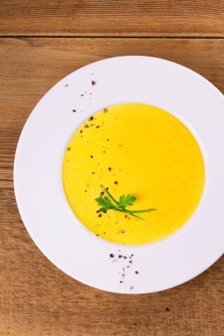 Kremalı Mısır çorbası biber, yeşil soğan ve maydanoz ile süslenmiş beyaz kase